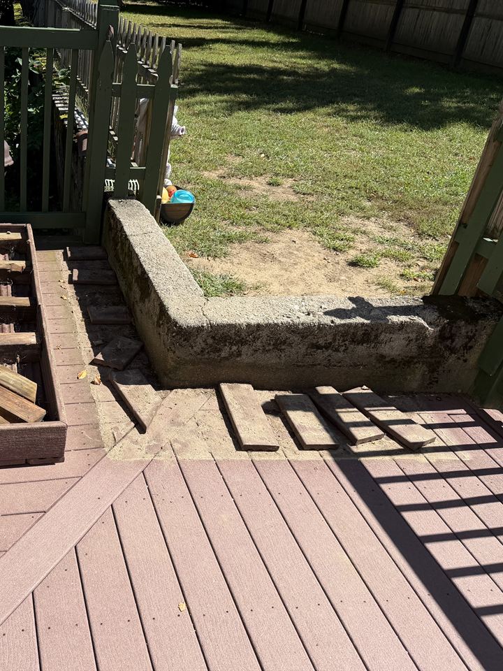 Deck with a mossy concrete curb and loose boards